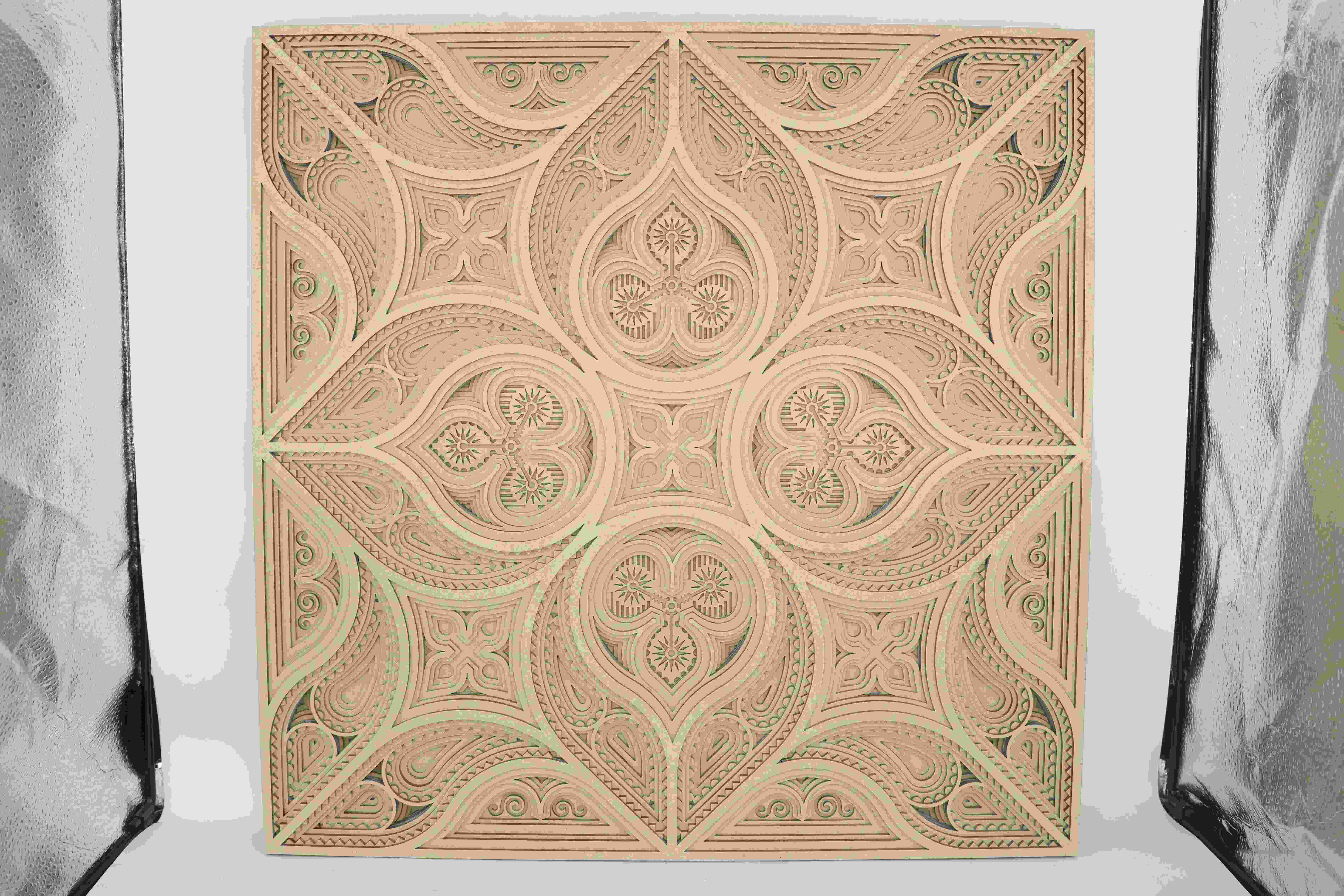 Ein geschichtetes Wand kunststück aus Holz, das mit einem Laser präzise geschnitten wurde, um komplizierte Muster und saubere Kanten zu bilden Ein geschichtetes Wand kunststück aus Holz, das mit einem Laser präzise geschnitten wurde, um komplizierte Muster und saubere Kanten zu bilden